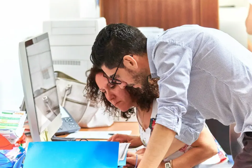 Due collaboratori CHECKS esaminano insieme una pratica alla scrivania